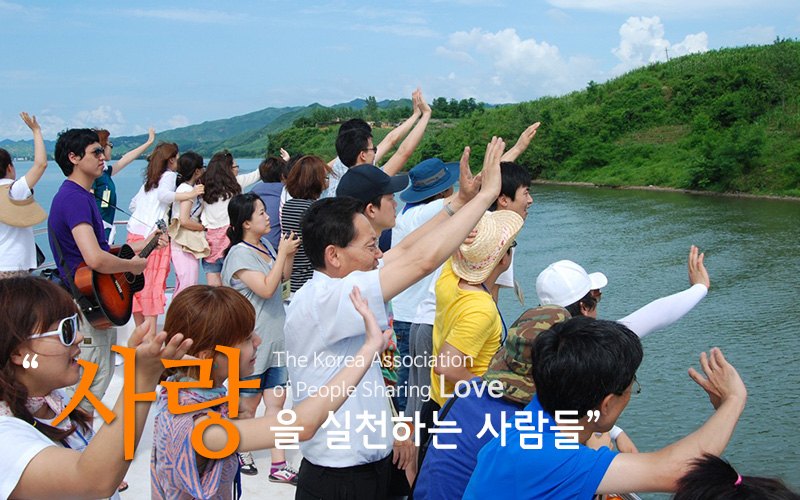 “사랑”을 실천하는 사람들 — 강 건너를 향해 손을 흔드는 참가자들