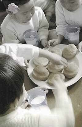 빵과 우유를 나누는 어린이들