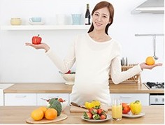 주방에서 과일을 들고 있는 임산부