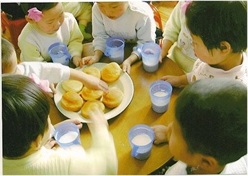 빵과 우유를 나누어 먹는 어린이들